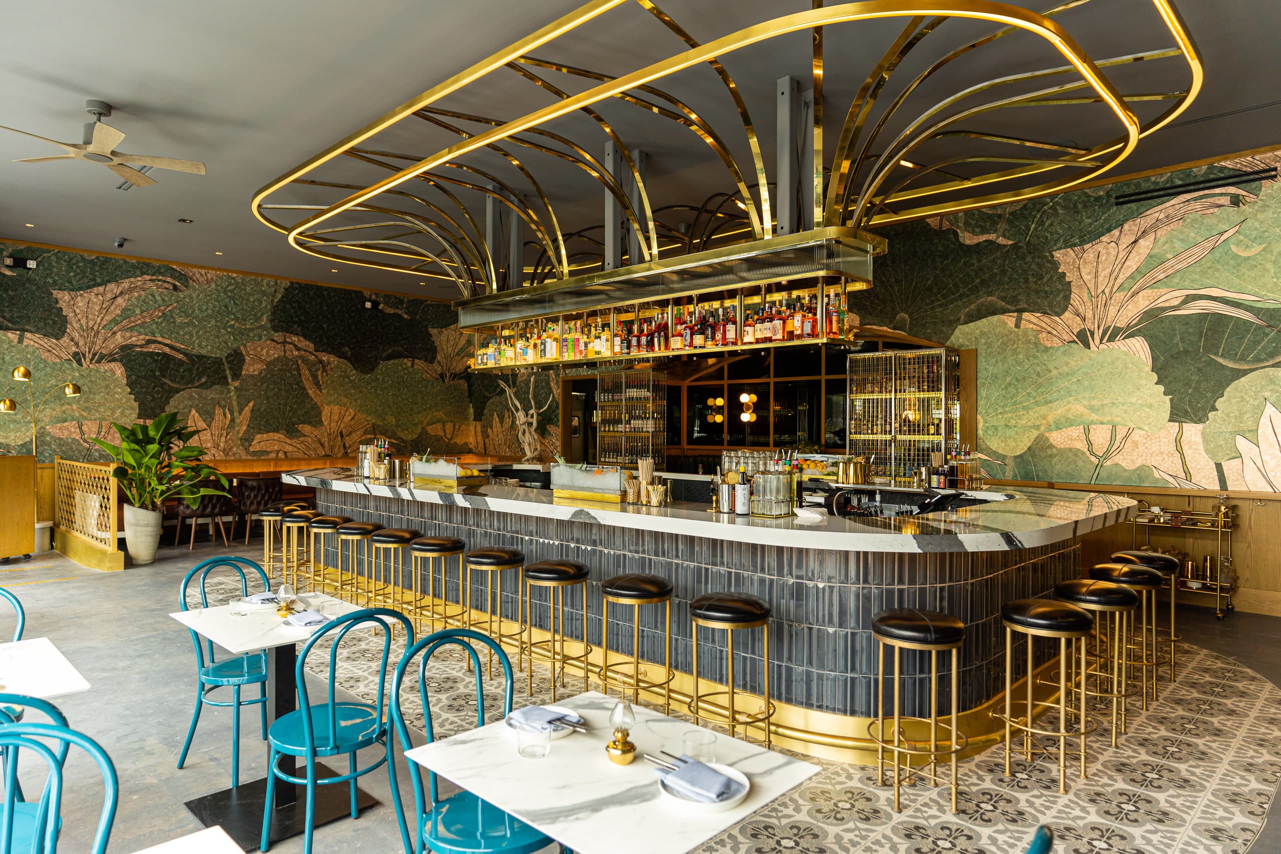 Central marble bar under a brass canopy at Kingfisher in Golden Hill, San Diego