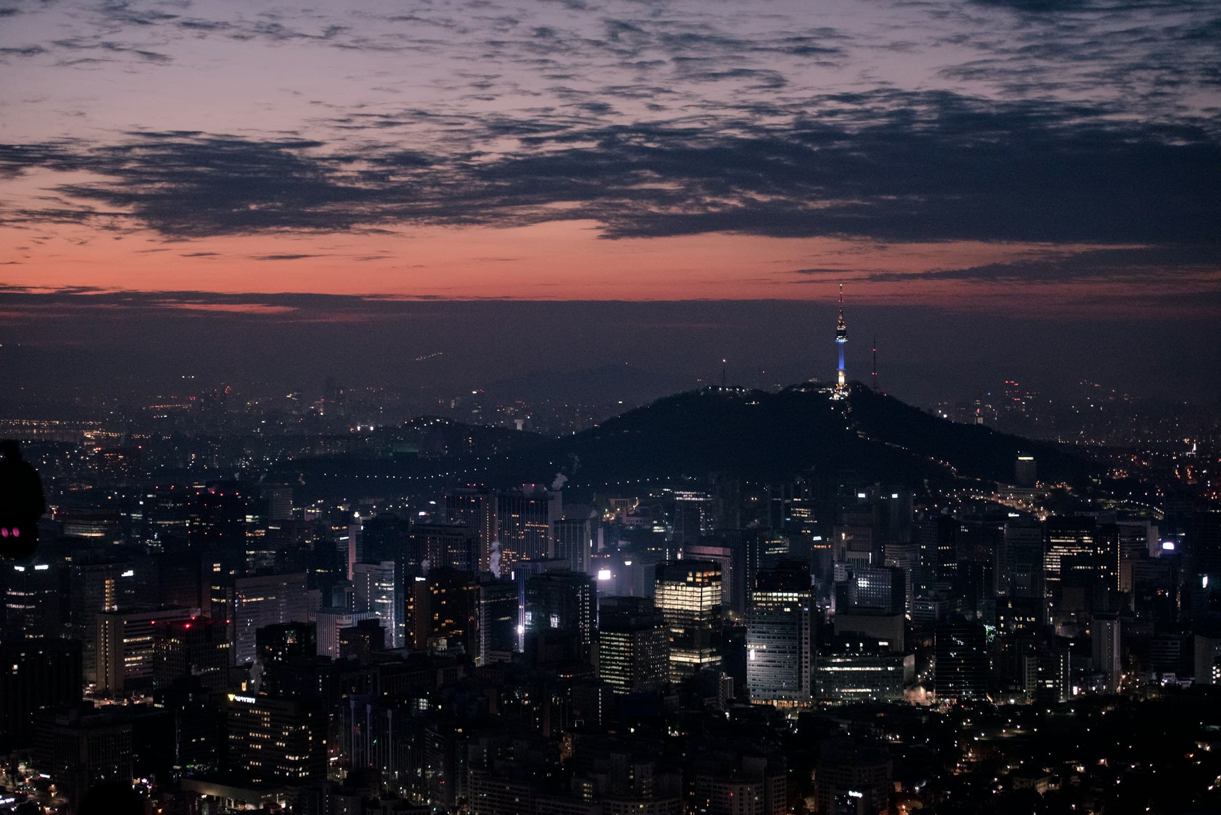Namsan Tower at dusk above the lit basin of Seoul