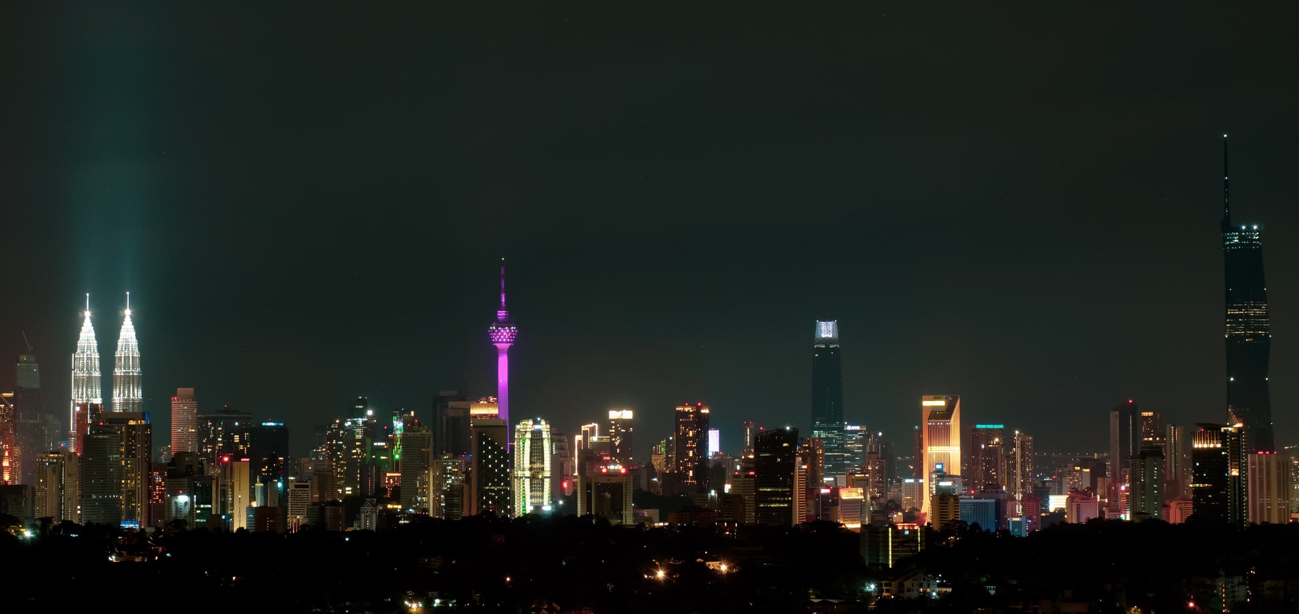 Kuala Lumpur at night, with the Petronas Twin Towers, a magenta KL Tower, and Merdeka 118