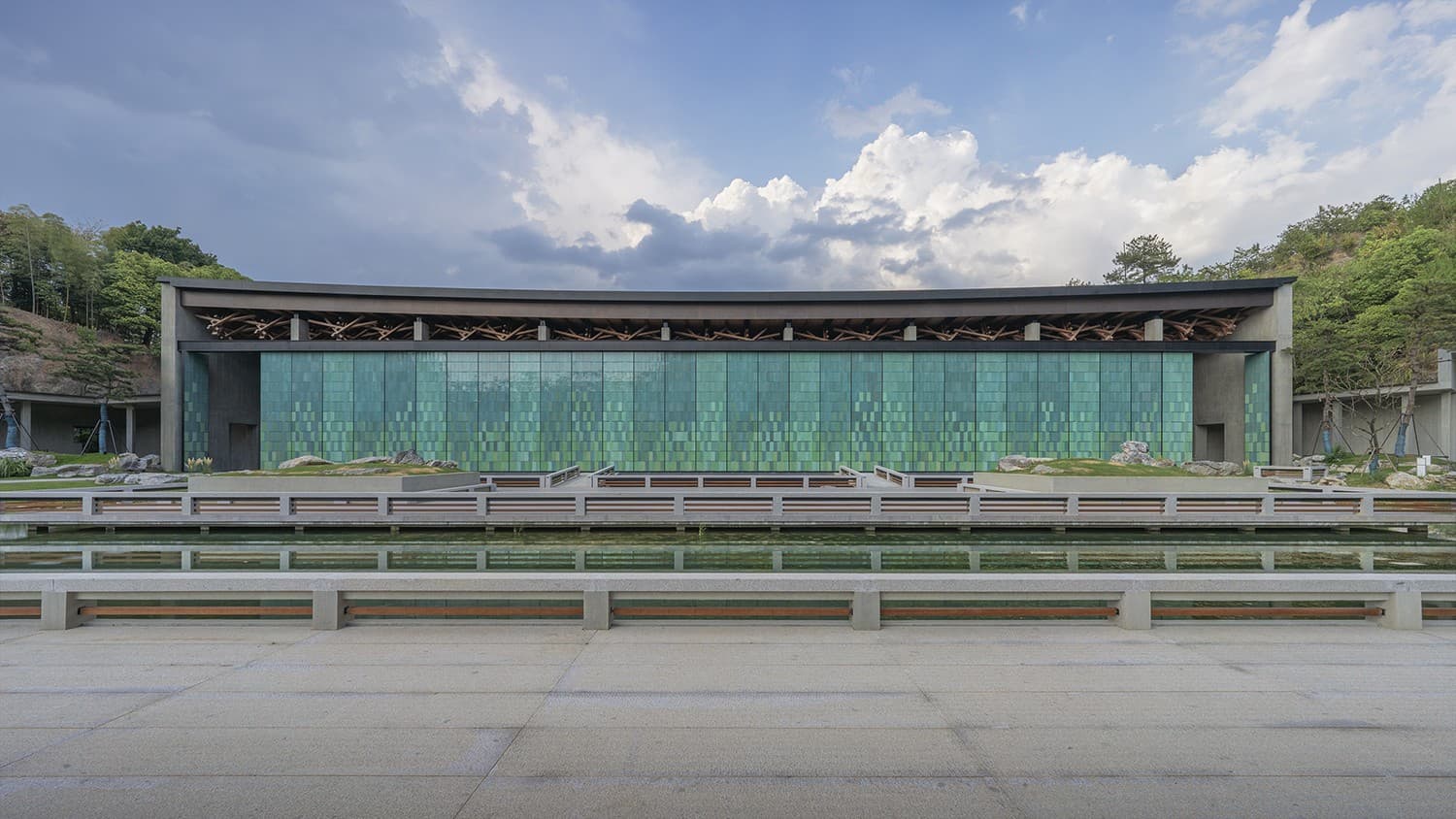 Longquan celadon screen panels across the facade of a hall at the Hangzhou National Archives, reflected in the pool in front of it