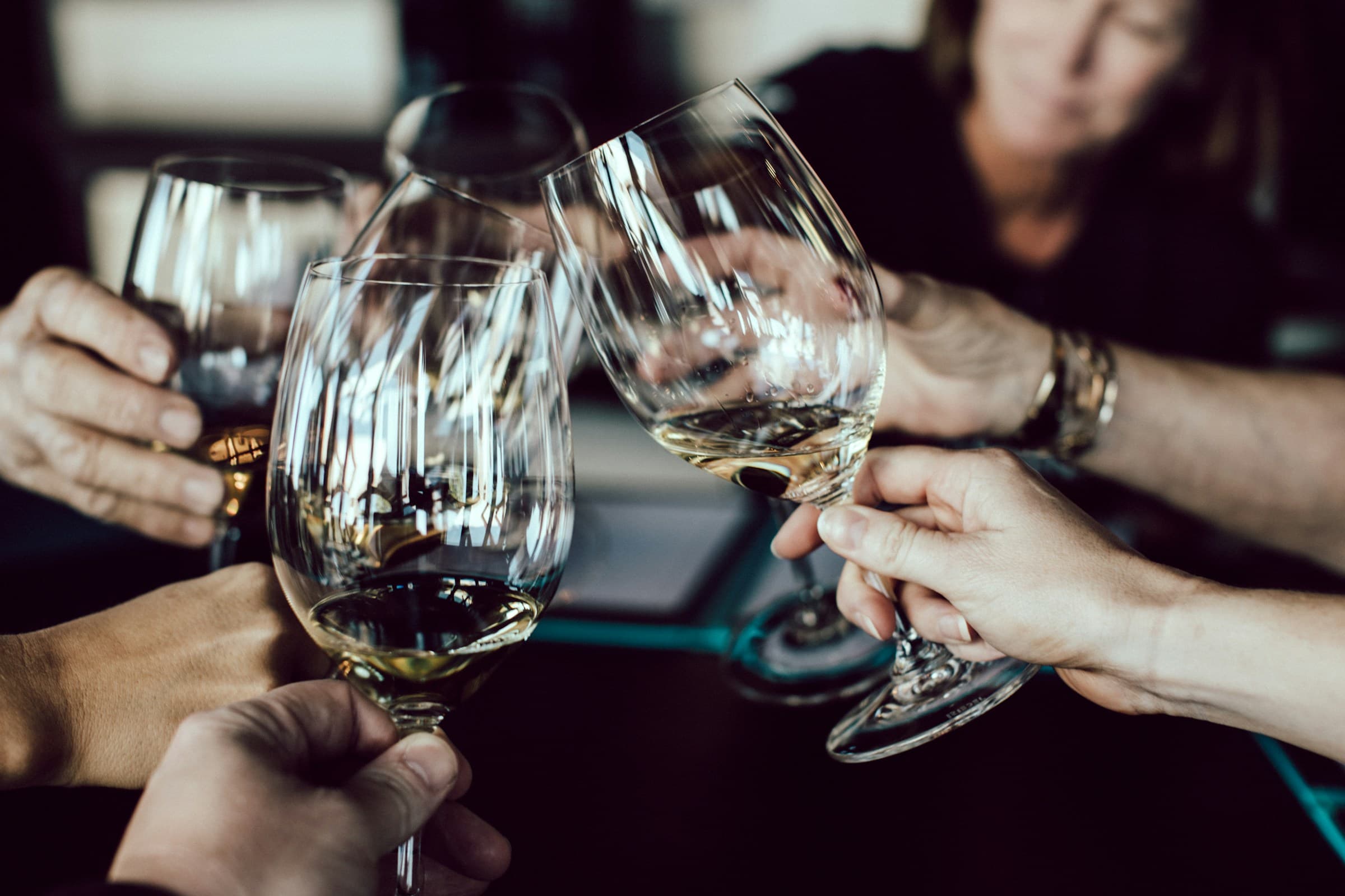 Wine glasses raised in a toast at a bar