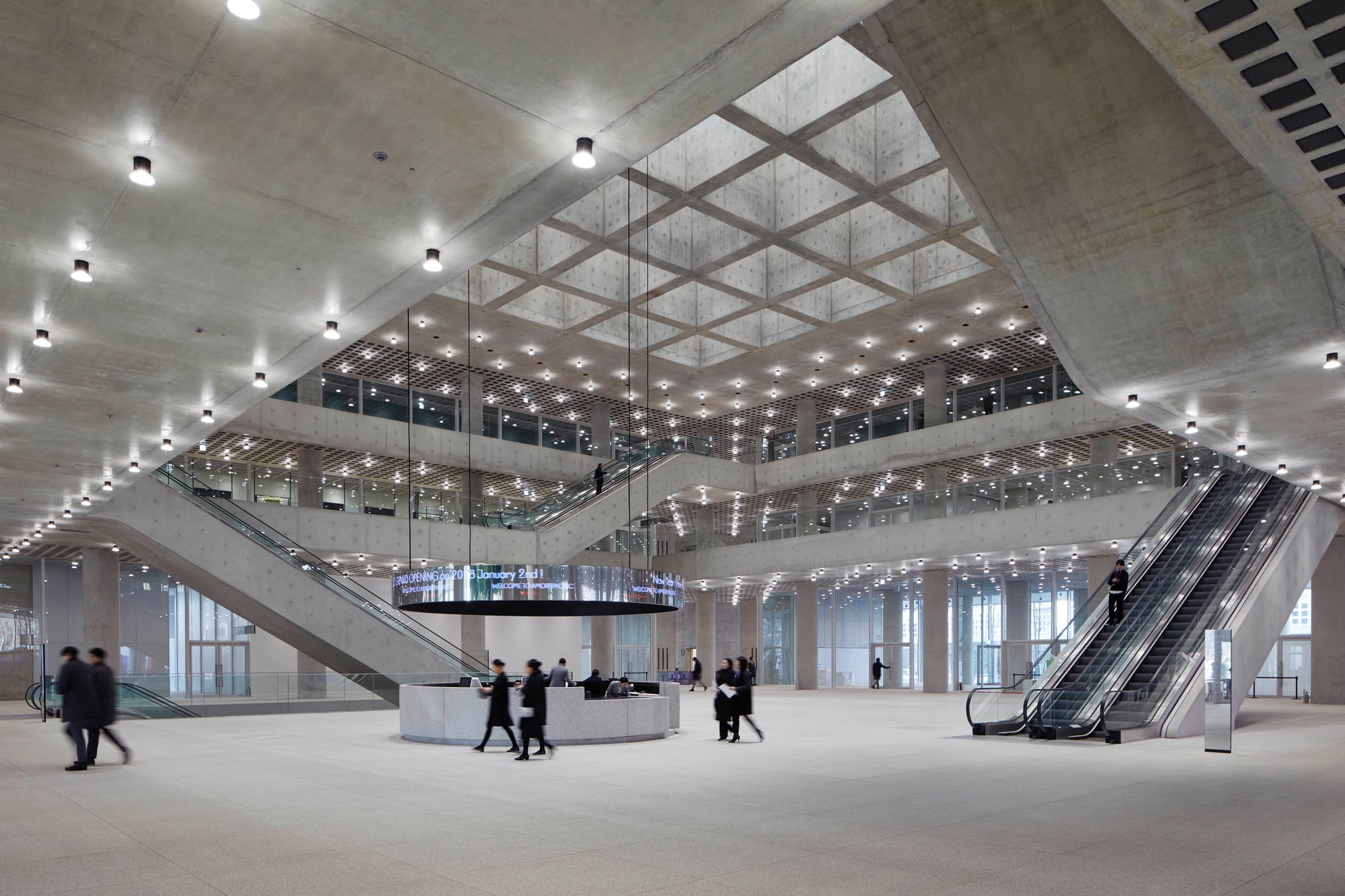 Public atrium with concrete columns and central skylight at Amorepacific Headquarters