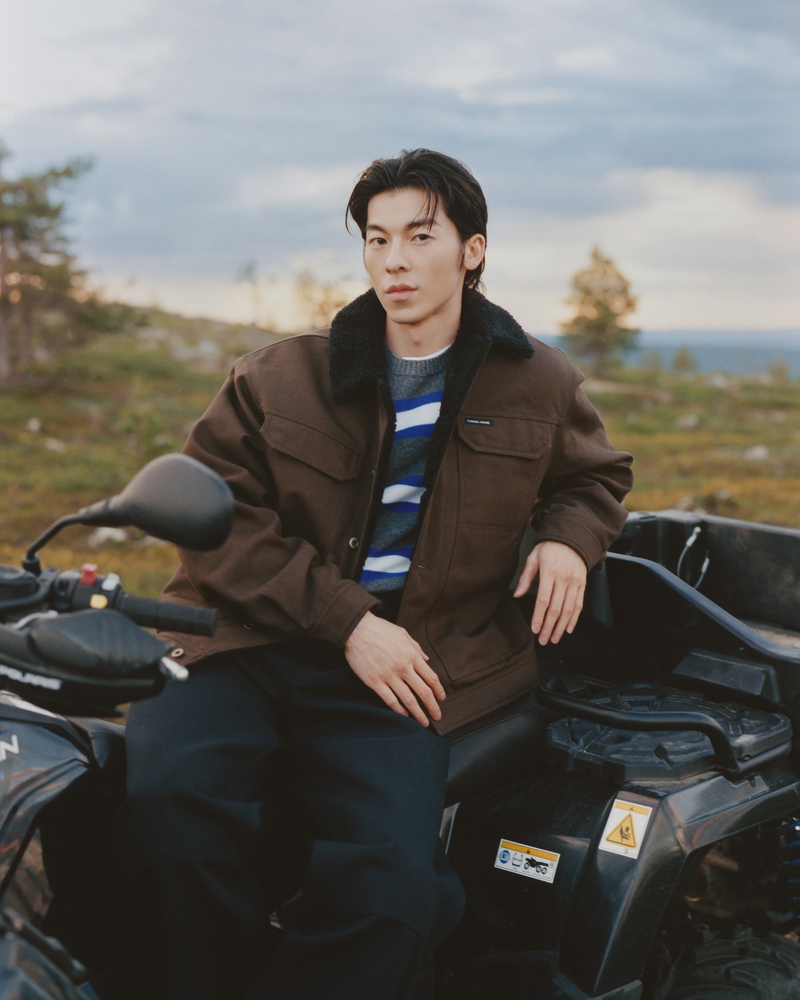 Greg Hsu on an ATV in Finnish Lapland wearing the Ash Jacket in Terra