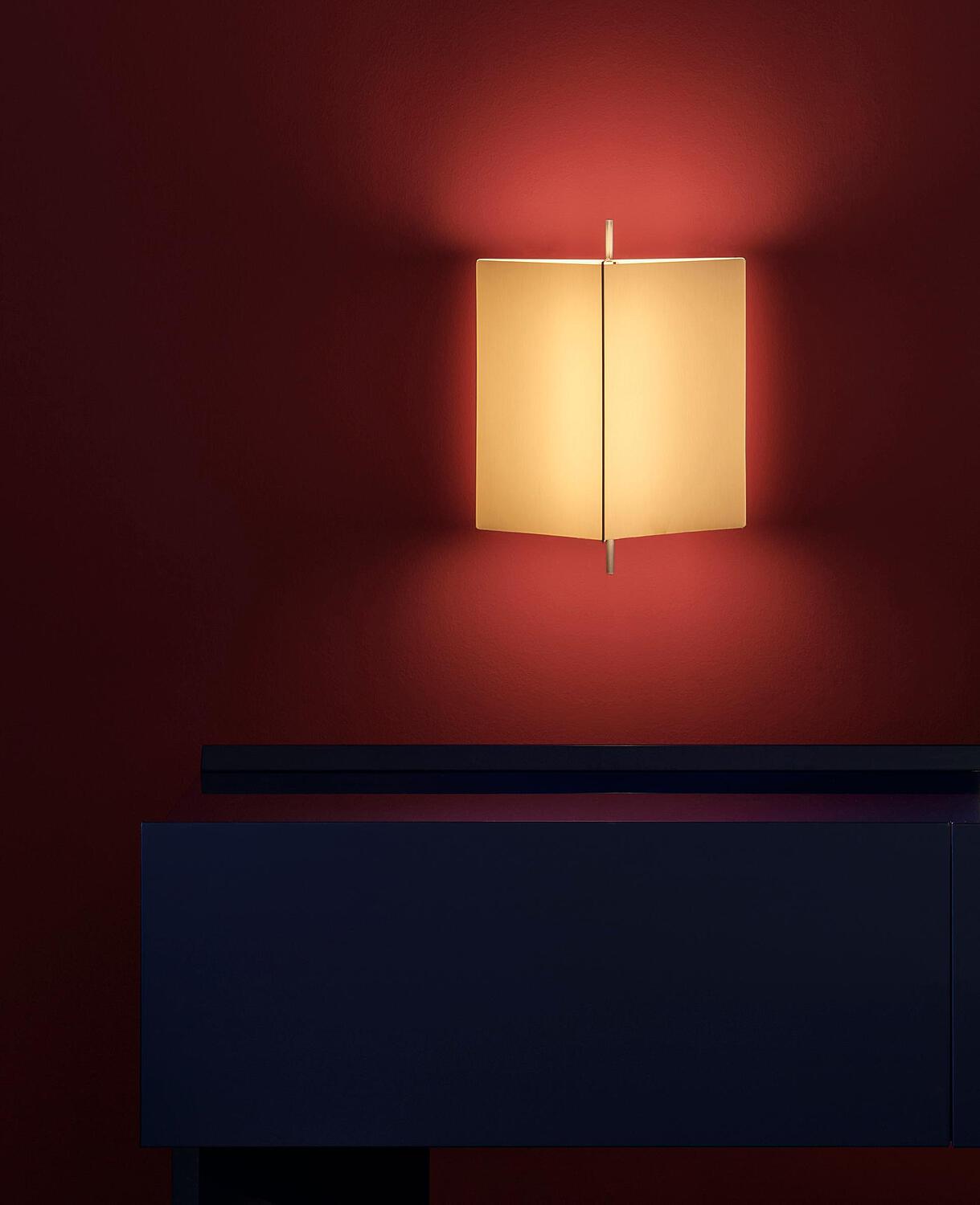 Cassina 3to9 wall lamp glowing on a deep red wall