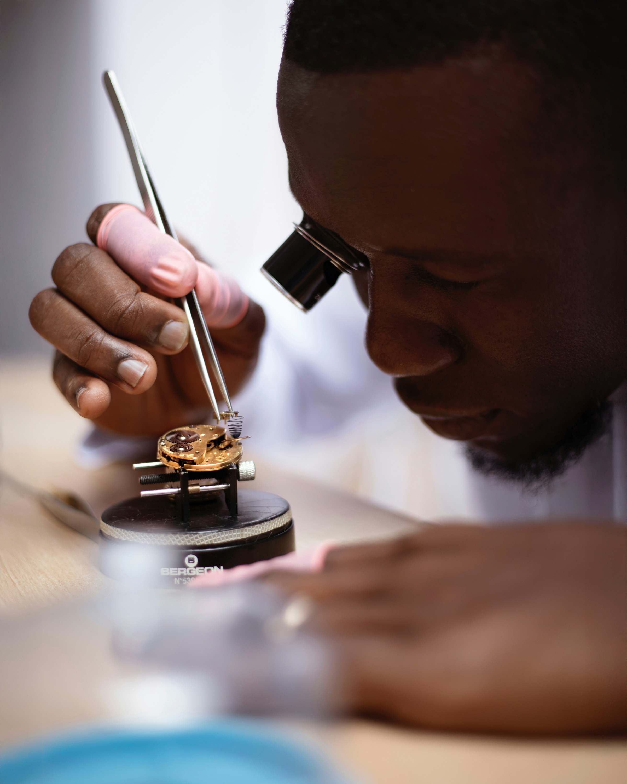 A watchmaker repairing a mechanical timepiece at the bench