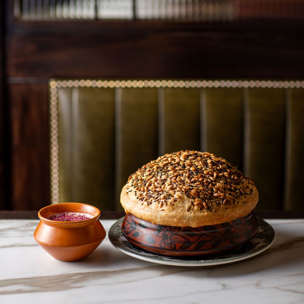 Sealed dum pot with seeded pastry lid and terracotta raita at Gymkhana London
