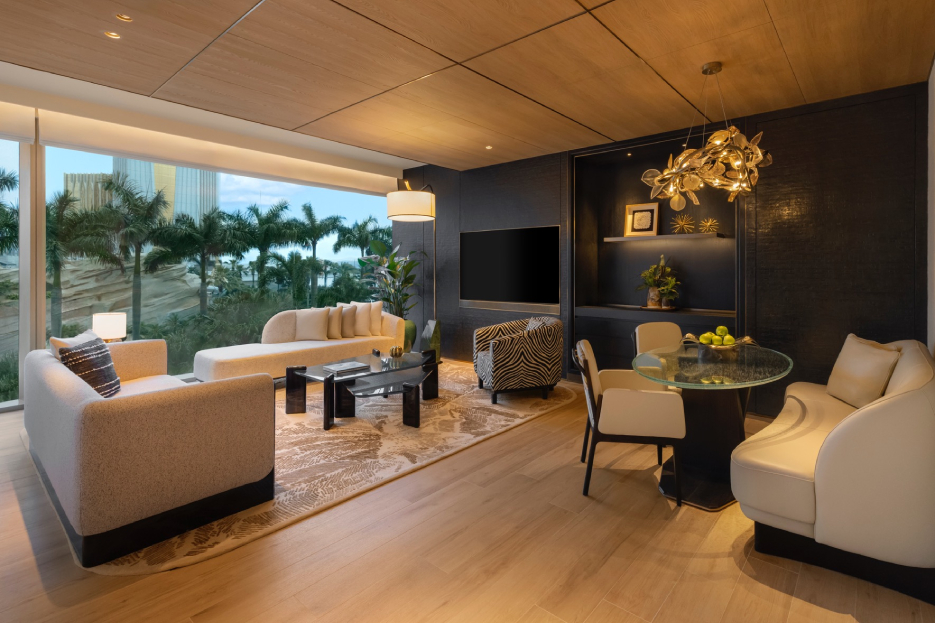 Living and dining area of a Capella at Galaxy Macau one-bedroom suite with jungle-motif furnishings and resort views