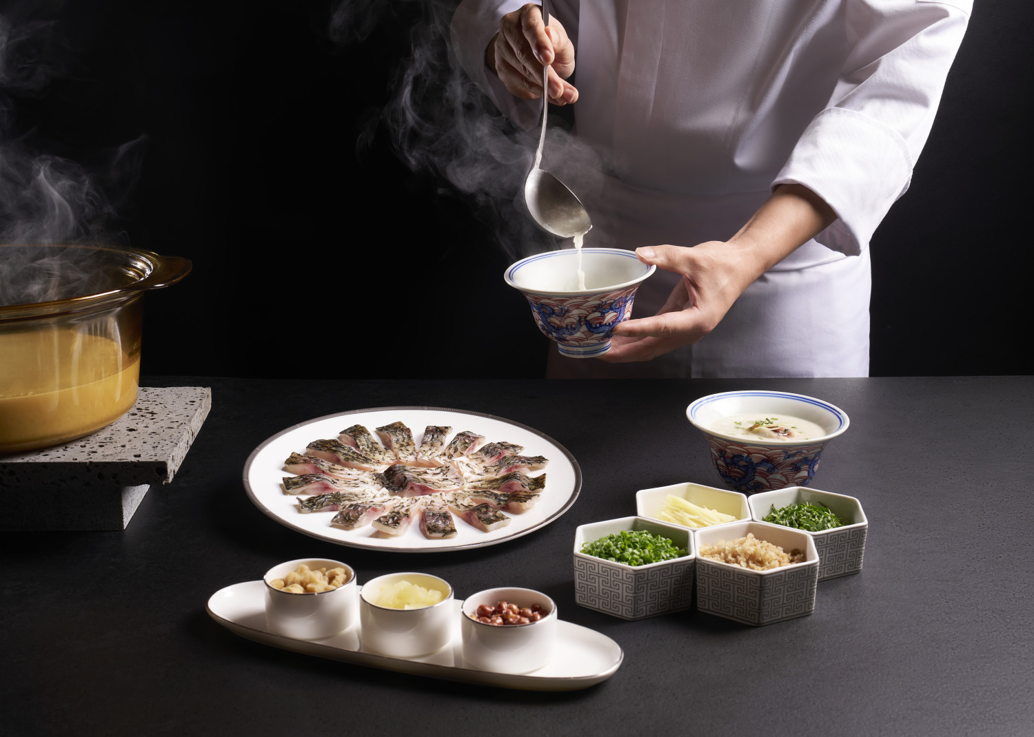 Chef pouring broth for crucian carp congee at Cherry Garden