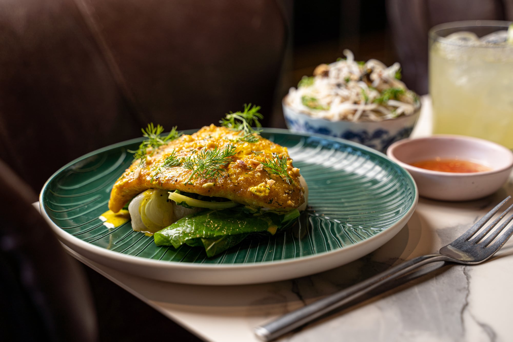 Turmeric-glazed fish with dill and peanuts plated at Kingfisher