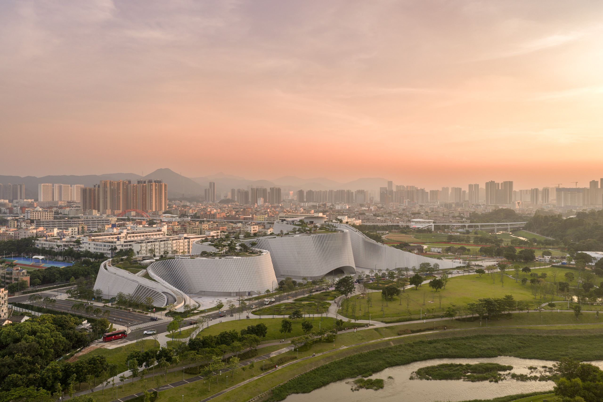 Granite-clad exterior of Shenzhen Natural History Museum rising beside Yanzi Lake in Pingshan