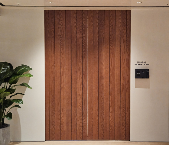 A tall wood-slat double door with a wall sign reading Personal Shopping Room