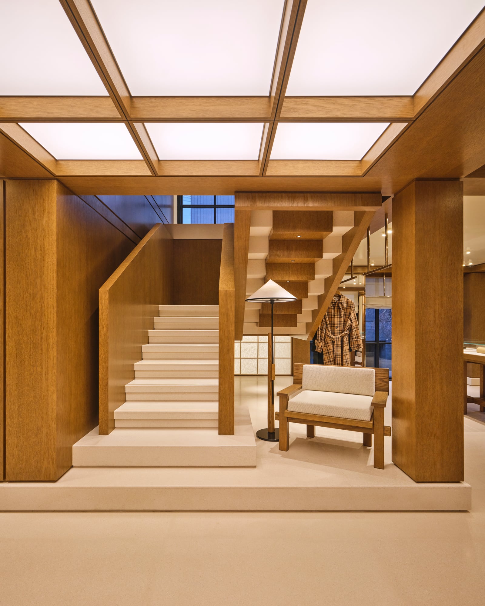 Wood-grid ceiling and stone staircase inside the Ami Paris Hannam-dong flagship in Seoul