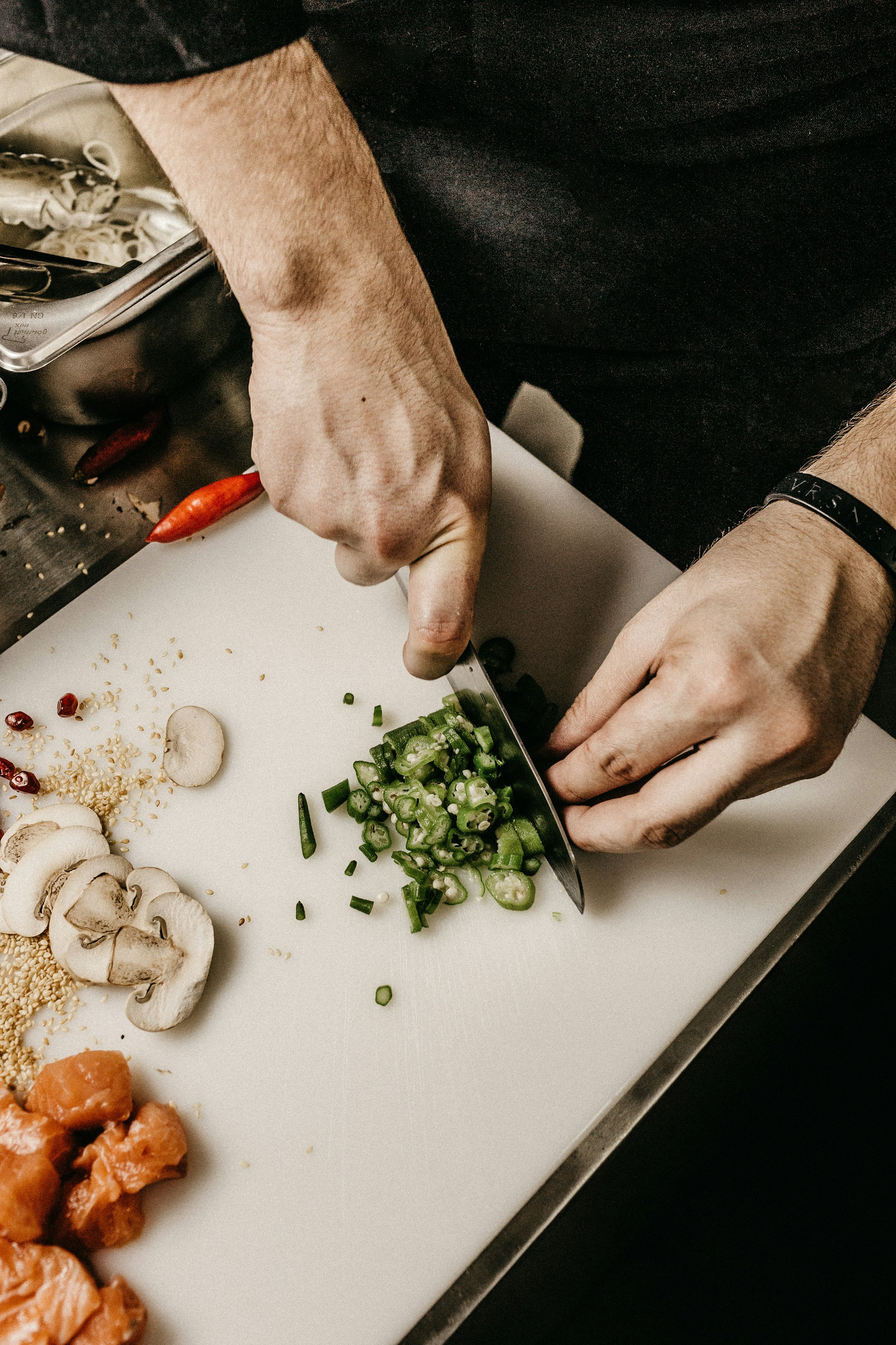 Chef preparing fish and vegetables at a sushi counter
