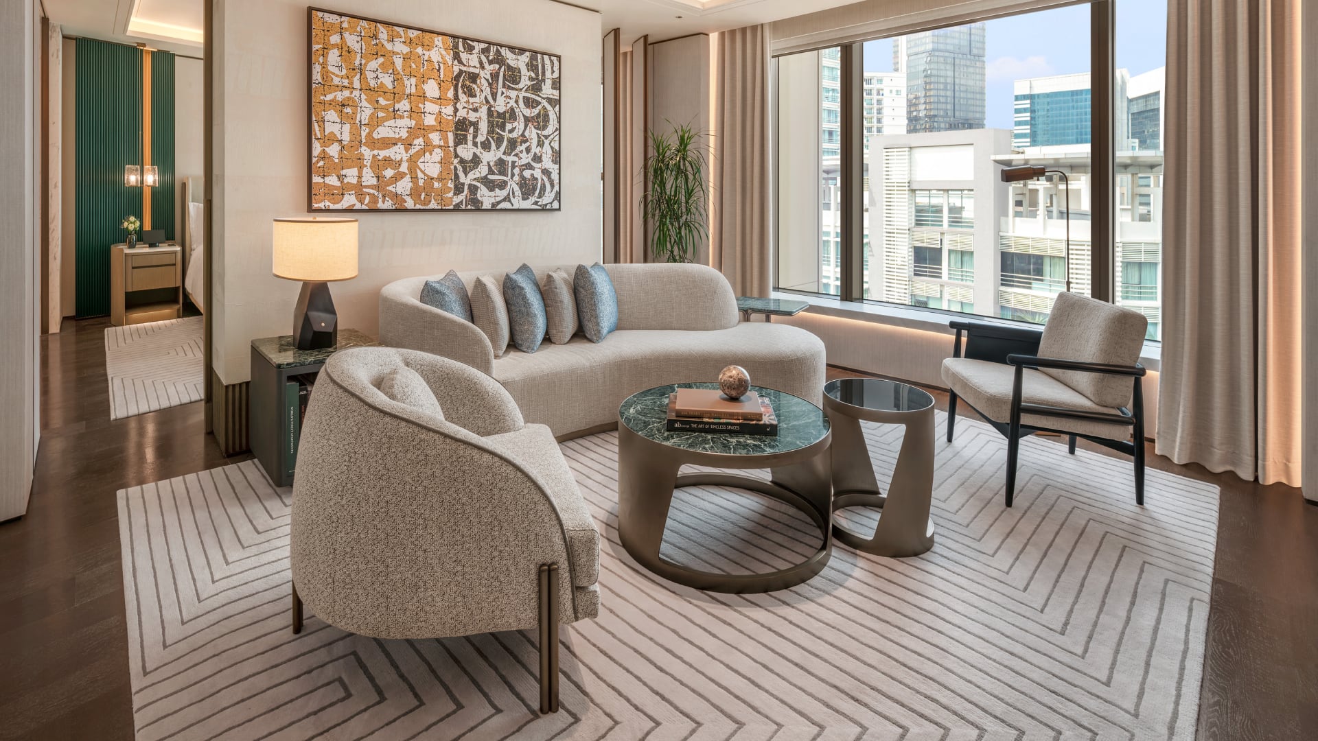 Signature Suite living room at Waldorf Astoria Kuala Lumpur with sofa seating, dining area, and floor-to-ceiling city windows