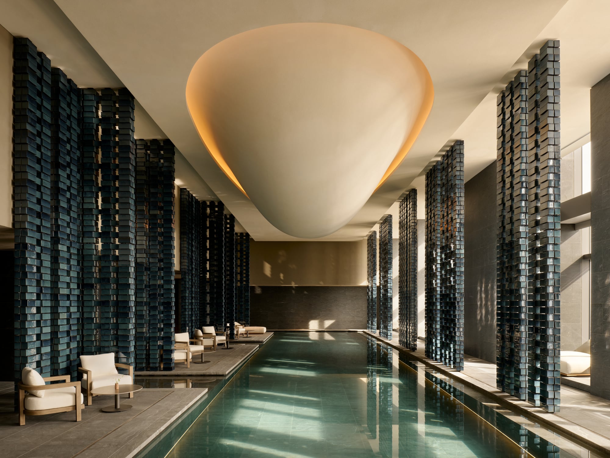 25-metre indoor lap pool in the Aman Residences Tokyo spa with teal brick screens and a sculptural ceiling volume